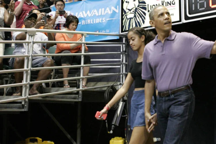 Barack Obama e sua filha Malia: os Obama chegaram a seus assentos antes do início da partida e foram saudados com gritos pelo público (Hugh Gentry/Reuters)