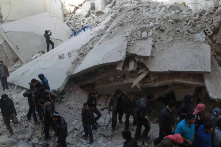 Moradores procuram por sobreviventes após o que ativistas disseram ter sido ataques aéreos por forças leais ao presidente sírio Bashar al-Assad, no bairro de Maysar, em Alepo (Jalal Alhalabi/Reuters)