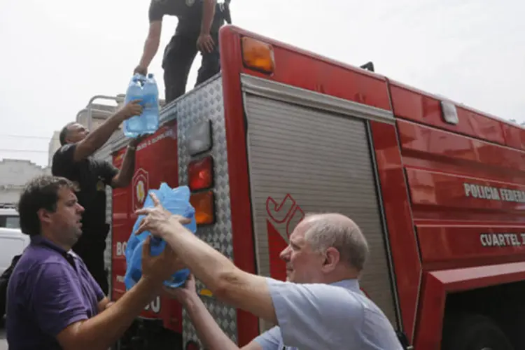 Bombeiros entregam água durante uma onda de calor que levou a recordes no consumo de energia em Buenos Aires, na Argentina (Enrique Marcarian/Reuters)