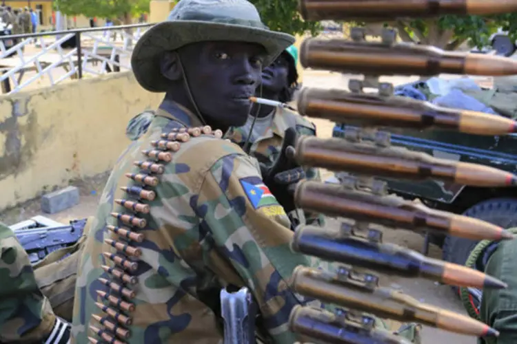 Soldado do exército do Sudão do Sul fuma perto de metralhadora na cidade de Malakal, perto da capital Juba (James Akena/Reuters)