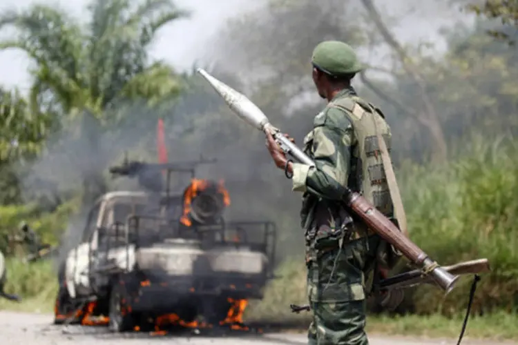 Soldado do exército do Congo olha para um veículo pegando fogo após sofrer uma emboscada próximo da vila Mazizi, na provícia de Kivu do Norte (Kenny Katombe/Reuters)