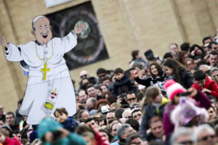 Uma caricatura representando o papa Francisco é erguida em meio ao fiéis durante a missa do Angelus, na Praça de São Pedro, Vaticano (Max Rossi/Reuters)