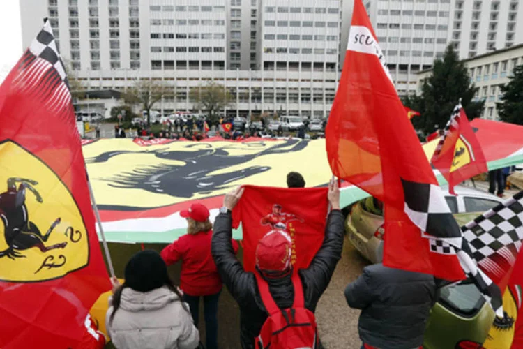Fãs da Ferrari homenageiam o ex-piloto Michael Schumacher, que completa 45 anos, em frente ao hospital de Grenoble, onde ele está internado (Charles Platiau/Reuters)