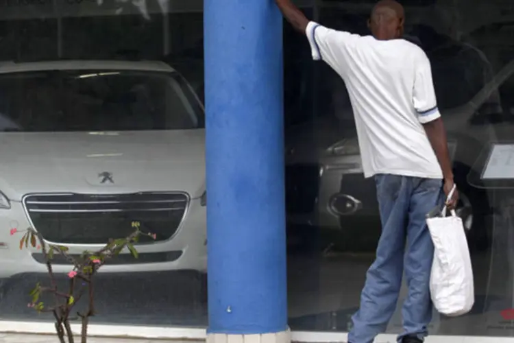 Cubanos olham para os preços dos carros da Peugeot em uma loja estatal da montadora em Havana, Cuba (Reuters)