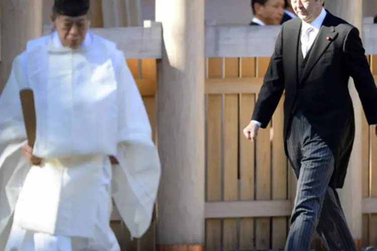 Primeiro-ministro do Japão, Shinzo Abe, é guiado por um sarcedore shinto enquanto realiza visita costumeira de ano-novo ao templo Ise, em Ise, na região central do Japão (Kyodo/Reuters)