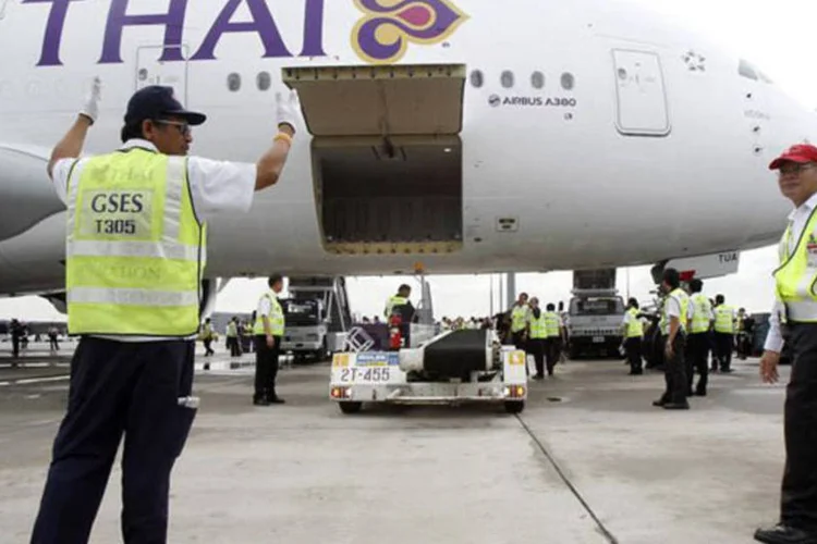 Equipe de solo da Thai Airways trabalha perto do primeiro Airbus Thai A380-800 conforme ele chega ao aeroporto internacional Suvarnabhumi em Bangcoc (Chaiwat Subprasom/Reuters)