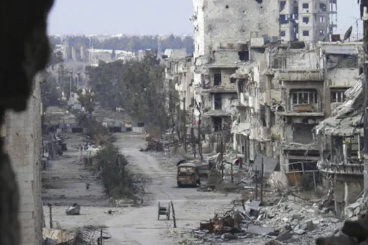 Edifícios danificados em uma rua deserta em uma área sitiada em Homs: (Thaer Al Khalidiya/Reuters)