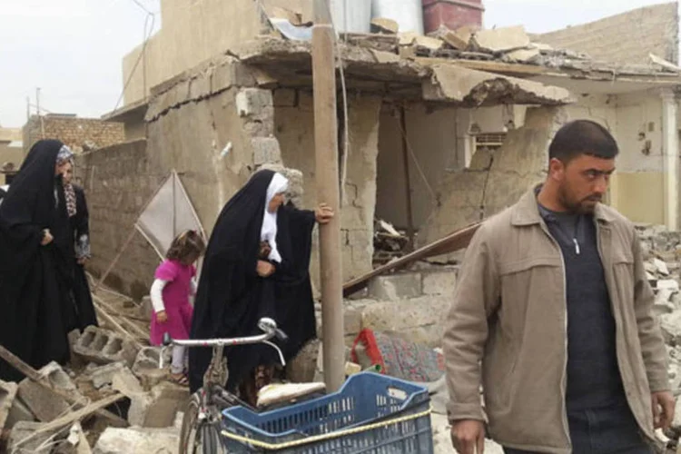 Moradores no local de um ataque a bomba na cidade de Tuz Khurmatu, norte de Bagdá, no Iraque (Reuters)
