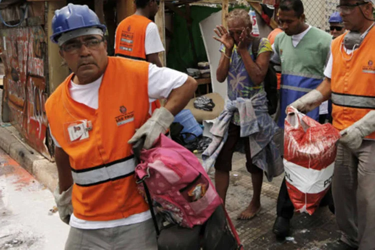 Mulher chora próxima de um assistente social após remorem a sua barraca, na região da Cracolândia, em São Paulo  (Nacho Doce/Reuters)