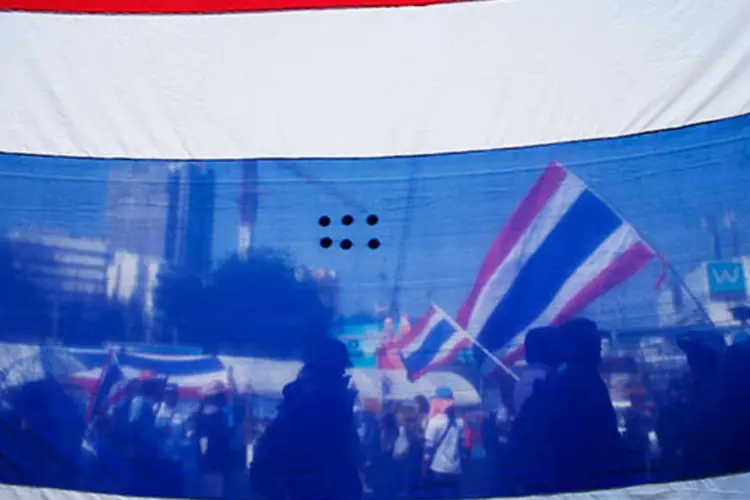 Manifestantes da oposição são vistos por trás da bandeira da Tailândia durante protesto (REUTERS/Athit Perawongmetha)