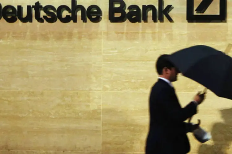 
	Homem com guarda-chuva passa em frente ao pr&eacute;dio do Deutsche Bank em Londres, na Inglaterra
 (Luke MacGregor/Reuters)