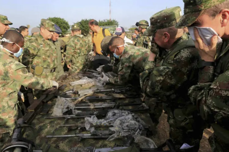
	Soldados do ex&eacute;rcito colombiano com as armas confiscados das Farc
 (Jose Miguel Gomez/Reuters)