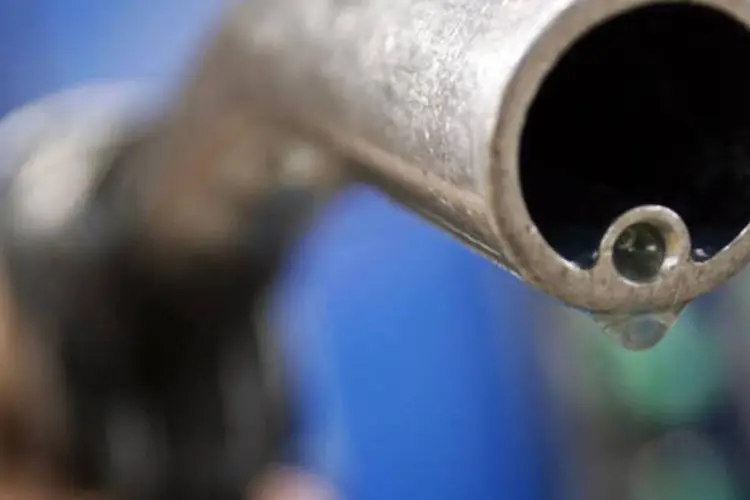 
	Motorista segura uma mangueira de gasolina
 (Luke MacGregor/Reuters)