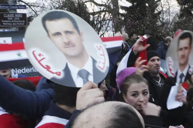 Manifestantes pro-Assad durante uma passeata em frente ao local onde a conferência de paz para a Síria está acontecendo, em Montreux (Kinda Makieh/Reuters)