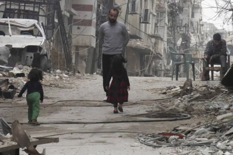 Civis em meio aos entulhos e destruição de uma área sitiada de Homs, na Síria (Thaer Al Khalidiya/Reuters)