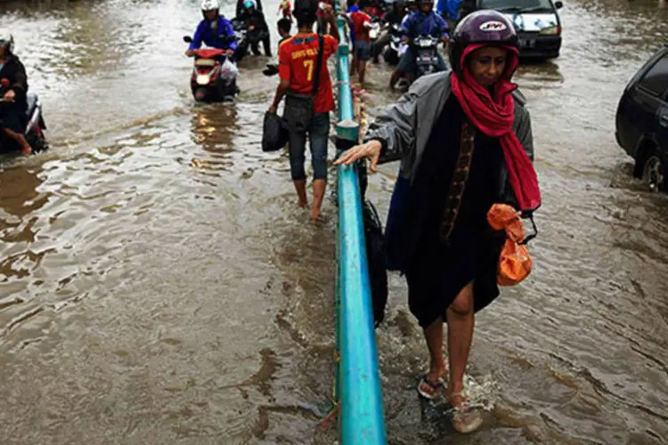 
	Pessoas atravessam enchente em Jacarta, na Indon&eacute;sia: a mensagem agora &eacute; mais enf&aacute;tica sobre o que o aumento da concentra&ccedil;&atilde;o de gases do efeito estufa
 (REUTERS/Beawiharta)