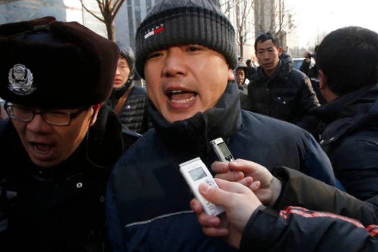 Policiais bloqueiam um grupo de jornalistas que tentavam entrevistar Zhang Qingfang, advogado do jurista Xu Zhiyong, após o seu julgamento em Pequim, na China (Kim Kyung-Hoon/Reuters)