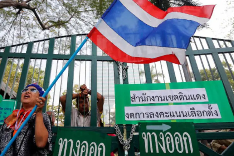 Manifestante anti-governo tenta bloquear a entrada de um colégio eleitoral durante um protesto em Bangcoc, na Tailândia (Damir Sagolj/Reuters)