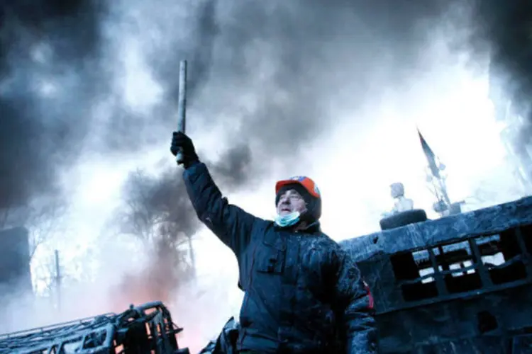 Homem em barricada perto do local de conflitos entre manifestantes contra o governo e tropas de choque em Kiev, Ucrânia, 25 de janeiro de 2014 (David Mdzinarishvili/Reuters)