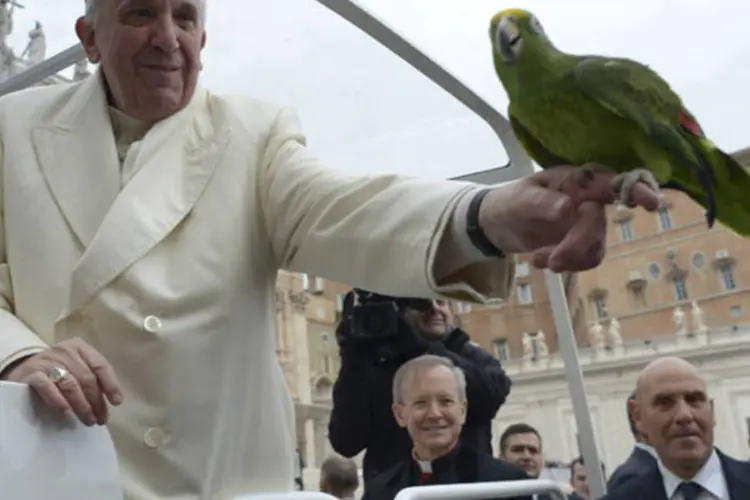 Papa Francisco segura um papagaio dado por um fiel durante a audiência de quarta-feira na Praça de São Pedro, no Vaticano (Osservatore Romano/Reuters)