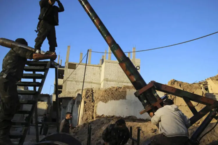 Combatentes do Exército Livre da Síria se preparam para atirar com um canhão em um dos subúrbios de Damasco (Mohammed Abdullah/Reuters)