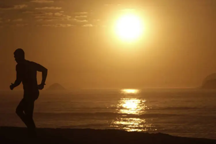 Homem corre durante o nascer do Sol na praia Barra da Tijuca, no Rio de Janeiro (Ricardo Moraes/Reuters)