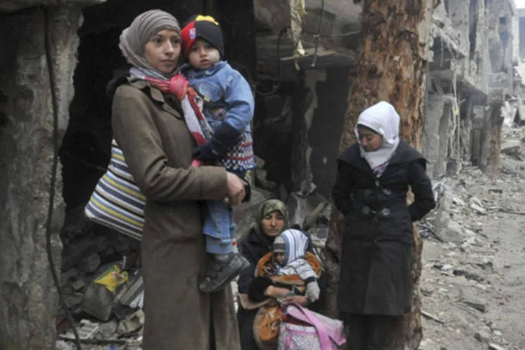 
	Civis recebem comida distribu&iacute;da pela ONU no campo de refugiados de al-Yarmouk, sitiado no sul de Damasco
 (SANA/Divulgação via Reuters)