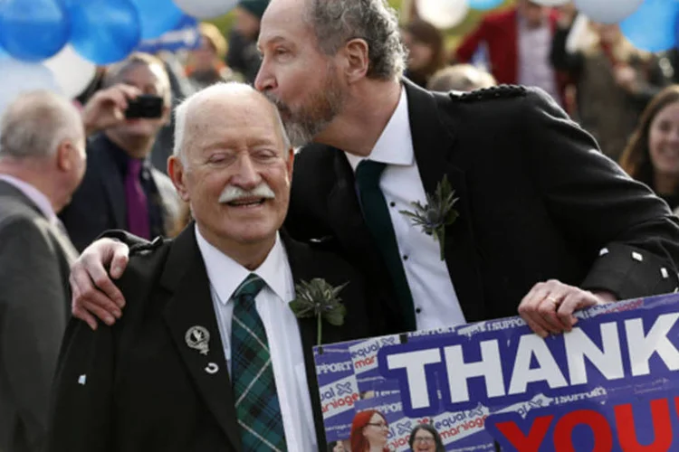 Casal se beija durante uma celebração simbólica de casamento em frente ao parlamento escocês, em Edimburgo, após aprovação do casamento entre homossexuais no país (Russell Cheyne/Reuters)