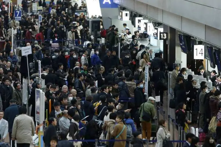 Pessoas fazem fila no aeroporto de Tóquio enquanto voos estão atrasados ou são cancelados devido à neve (REUTERS/Yuya Shino)