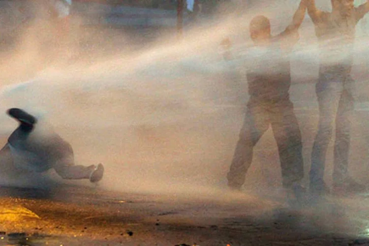 
	Opositores s&atilde;o atingidos por jato d&#39;&aacute;gua lan&ccedil;ado pela pol&iacute;cia durante protesto contra Nicolas Maduro, em Caracas, na Venezuela: o governo atribui a viol&ecirc;ncia aos infiltrados
 (REUTERS/Carlos Garcia Rawlins)