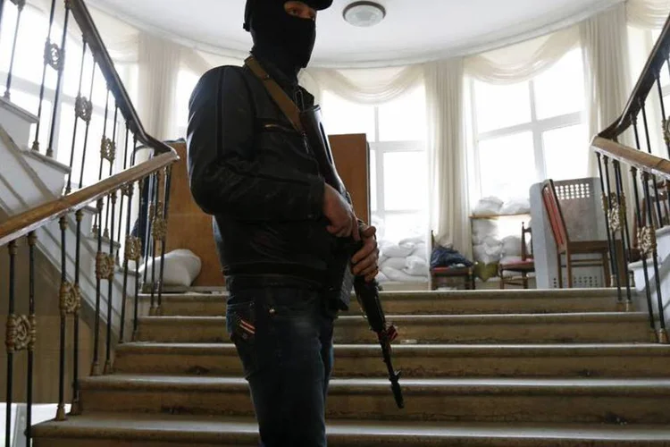 
	Um homem pr&oacute;-R&uacute;ssia armado faz guarda ap&oacute;s ocupa&ccedil;&atilde;o de Prefeitura na Ucr&acirc;nia: a ocupa&ccedil;&atilde;o de edif&iacute;cios da administra&ccedil;&atilde;o p&uacute;blica no sudeste da Ucr&acirc;nia se intensificou nas &uacute;ltimas 24 horas (REUTERS/Vasily Fedosenko)