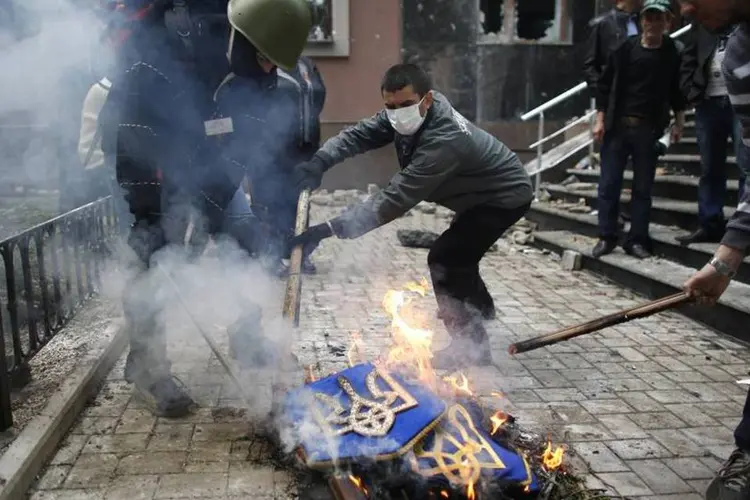 
	Ativistas queimam bandeira da Ucr&acirc;nia: em mar&ccedil;o, Moscou anexou a Crimeia
 (REUTERS/Marko Djurica)