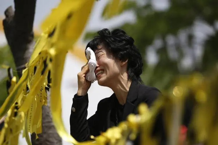 Parente de vítima do naufrágio sul-coreano chora diante de fitas amarelas dedicadas aos passageiros mortos e desaparecidos  (REUTERS/Kim Hong-Ji)