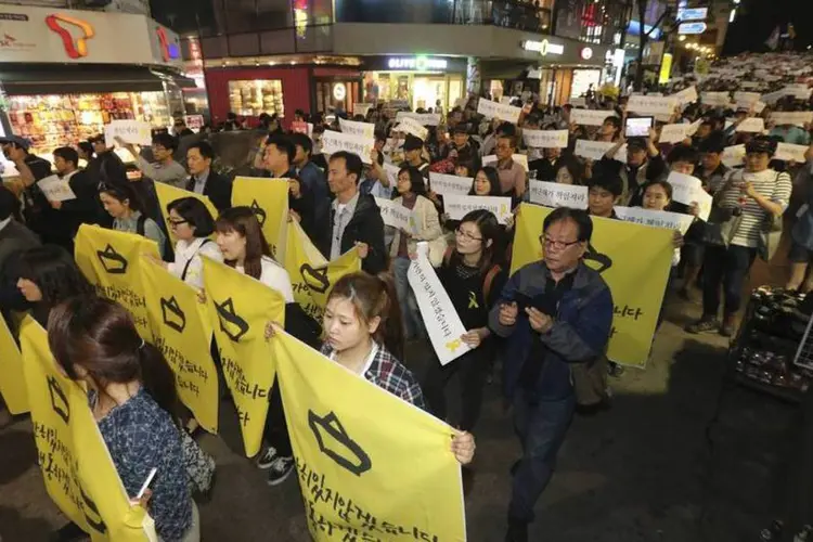 
	Pessoas marcham ap&oacute;s participarem de vig&iacute;lia em mem&oacute;ria das v&iacute;timas do naufr&aacute;gio da barca sul-coreana Sewol: 304 pessoas morreram
 (REUTERS/Yonhap)