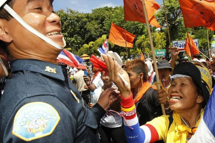 
	Manifestante anti-governo brinca com um militar durante protesto em Bancoc: os manifestantes exigem uma reforma do sistema pol&iacute;tico que consideram corrupto&nbsp;
 (REUTERS/Chaiwat Subprasom)