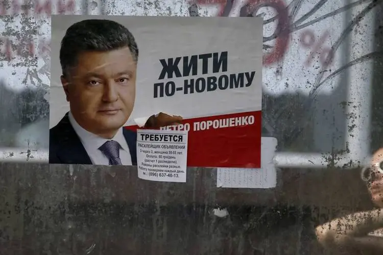 Mulher passa por propaganda eleitoral do candidato Petro Poroshenko, na Ucrânia (REUTERS/Gleb Garanich)