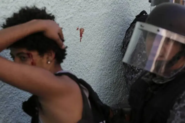 Policial aborda manifestante ferida durante confrontos em protesto contra a Copa em São Paulo (REUTERS/Lunae Parracho)