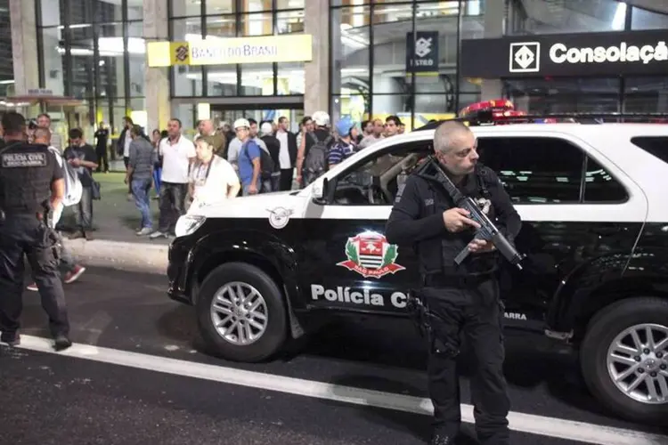 Policial segura arma durante protesto contra a Copa do Mundo em São Paulo (REUTERS/Stringer/Brazil/Chico Ferreira)