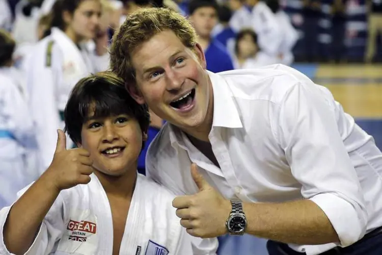 Príncipe Harry posa com criança durante visita ao Minas Tênis Clube, em Belo Horizonte (REUTERS/Sergio Perez)