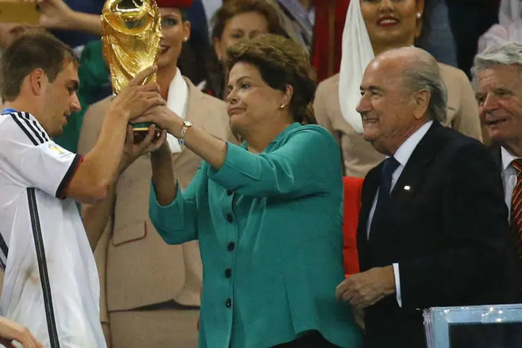 
	Dilma entrega ta&ccedil;a para o capit&atilde;o do time alem&atilde;o: vaias se transformaram em ofensas
 (REUTERS/Kai Pfaffenbach)