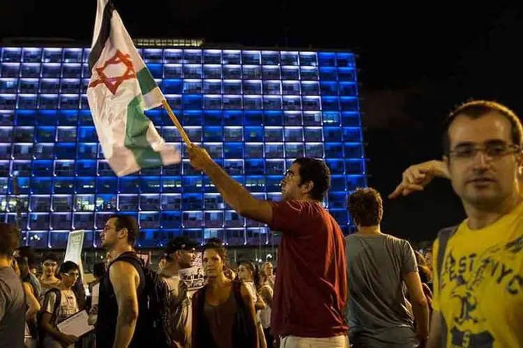 Homem segura uma bandeira em Tel Aviv (REUTERS/Baz Ratner)