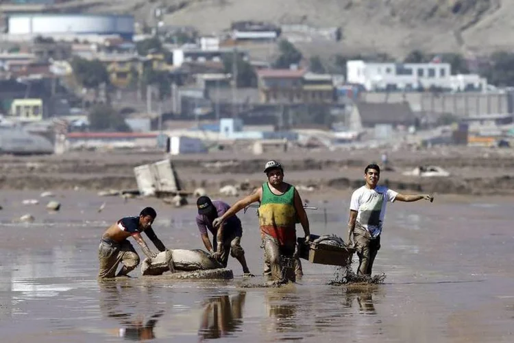 
	Inunda&ccedil;&otilde;es no Chile: Moradores retiram objetos de local inundado em Cha&ntilde;aral.
 (REUTERS/Ivan Alvarado)