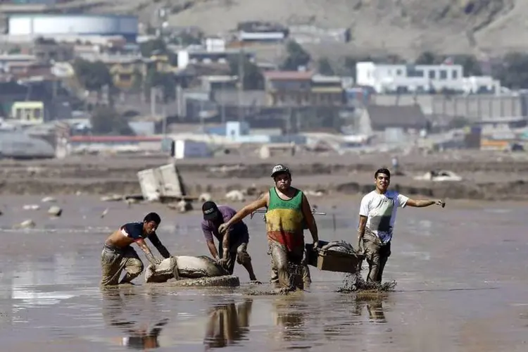 Moradores retiram objetos de local inundado em Chañaral, no Chile (REUTERS/Ivan Alvarado)