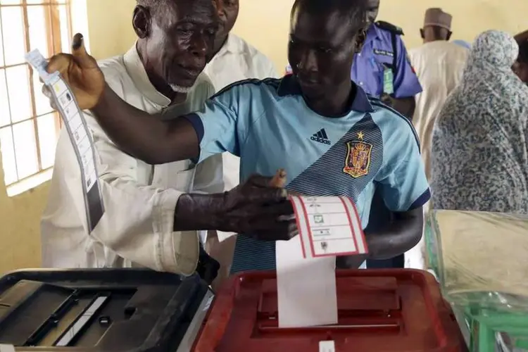 Homens depositam seus votos em urnas na Nigéria (REUTERS/Goran Tomasevic)