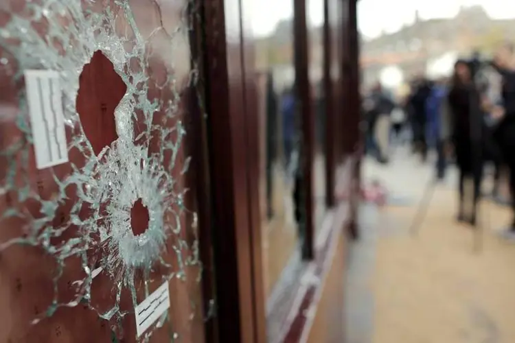 
	Marcas de tiro em um dos restaurantes atingidos: dois dos envolvidos no atentado vinham de Bruxelas, diz emissora belga
 (Reuters)