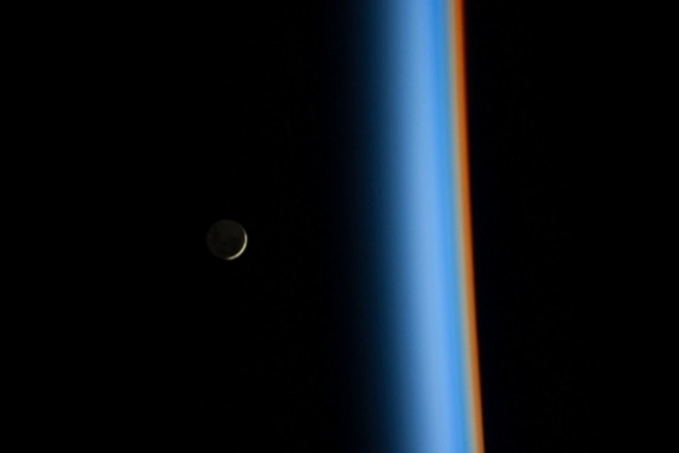 Lua crescente aparece ao lado da atmosfera colorida da Terra