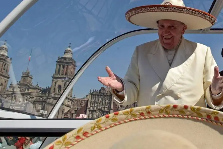 Papa Francisco gesticulando ao vestir um chapéu Mariachi dado a ele por alguém na multidão na Praça Zócalo na Cidade do México (REUTERS/Mexico Presidency/Handout via Reuters)