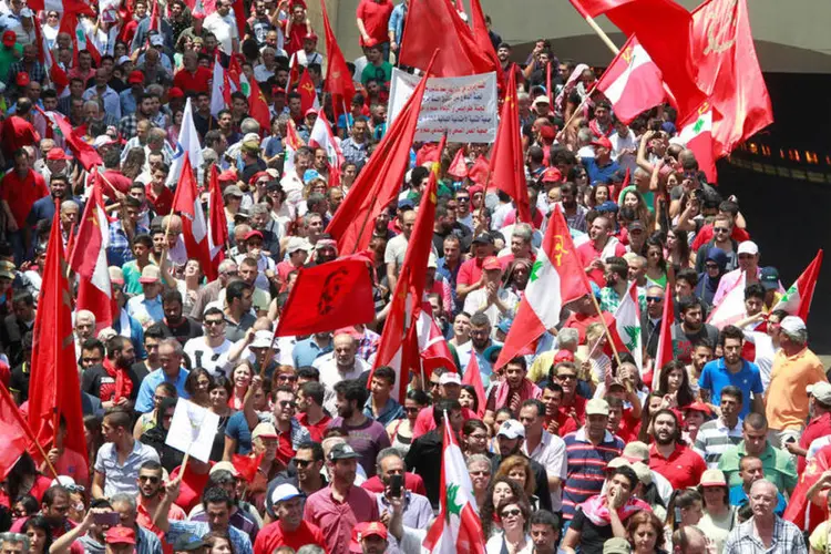 Manifestantes carregam bandeiras no Líbano, em manifestação que marca o Dia Internacional do Trabalho (REUTERS/Aziz Taher)