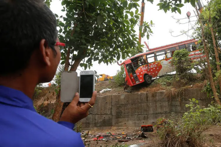 Acidente na Índia: homem tira foto de destroços de ônibus que sofreu acidente (REUTERS/Shailesh Andrade)