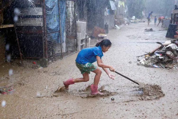 Inundações: filipina tenta remover a lama de casa após enchente (REUTERS/Erik De Castro)